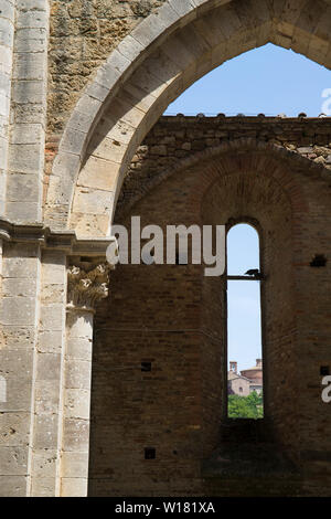 Detail eines Bogens in San Galgano Abbey mit einem Fenster mit Blick auf das nächste Gebäude. Vertikale erschossen. Stockfoto