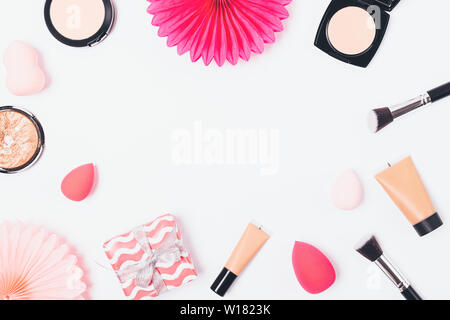 Make-up-Produkte und Geschenkbox mit Papier Dekorationen auf weißem Hintergrund, festliche flachen Rahmen legen. Stockfoto