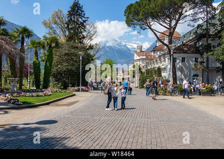 Straße Szenario auf Passanten Promenade in Meran mit Alpen im Hintergrund. Meran. Provinz Bozen, Südtirol, Italien. Europa. Stockfoto