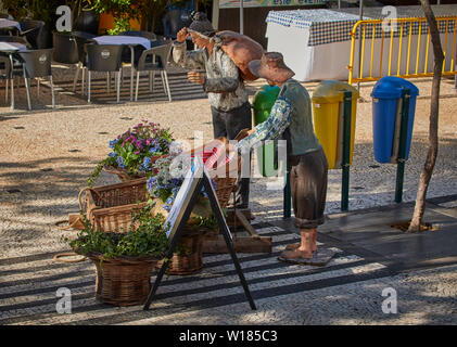 Traditionell Mann und Frau drücken Weidenkörbe gekleidet. Street Art, Werbung, in der Altstadt von Funchal, Madeira, Portugal, Europäische Union Stockfoto