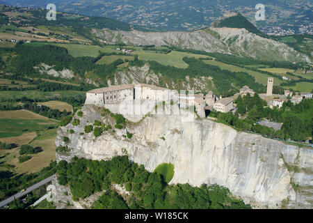 LUFTAUFNAHME. Mittelalterliche Festung auf einer isolierten mesa. San Leo, Provinz Rimini, Emilia-Romagna, Italien. Stockfoto