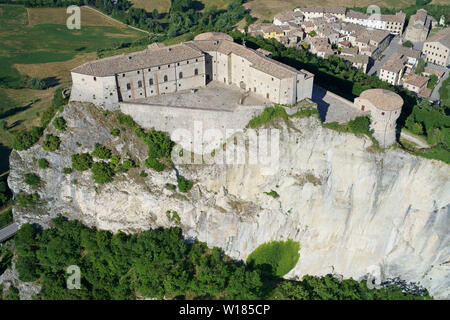 LUFTAUFNAHME. Mittelalterliche Festung auf einer isolierten mesa. San Leo, Provinz Rimini, Emilia-Romagna, Italien. Stockfoto