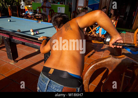 Ein Mann mit Tattoos auf seinem Rücken ist spielen Pool in einer Pension in Siem Reap, Kambodscha. Stockfoto