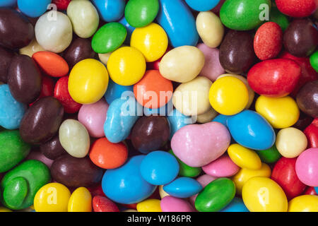 Bunte Süßigkeiten Hintergrund. Die Muttern in der multi-farbige Glasur Dragiermaschinen u.a.. Stapel der bunt gestrichenen Süßigkeit. Stockfoto