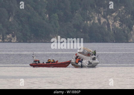 Fort Augustus, UK, 29. Juni 2019. Passagiere auf einem Cruiser von Rnli lifeboat und Küstenwache am Samstag Abend gerettet werden, als ihr Boot lief auf Loch Ness. Die 4-Personen Schiff, von Caley Cruisers betrieben, wurde 'hart geerdet", so ein Mitglied der Küstenwache Team. Alle Passagiere wurden gerettet und bis Fort Augustus, wo die Küstenwache versuchte, Unterkunft für Sie zu finden. Direktor von Caley Cruisers, Audrey Hogan, der am Tatort war, sagte: "Die Fahrgäste nie in der Position gewesen sein sollte." Quelle: Andrew Smith Stockfoto