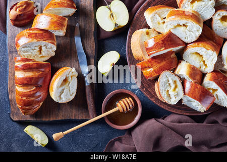 Ansicht von oben der frisch gebackene Brötchen mit Apple jam Füllung auf eine Steingut Teller auf eine Küche im rustikalen Holztisch, horizontale Ansicht von oben Stockfoto