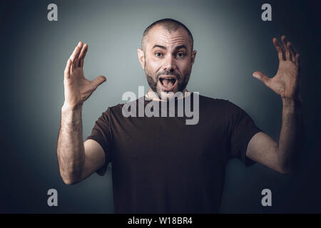Porträt eines Mannes mit überraschten Ausdruck und offenen Armen vor, Studio gedreht. Stockfoto