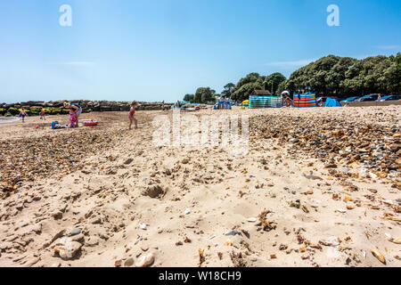 Ein Blick hinunter Avon Strand bei Mudeford, Christchurch, Dorset, Großbritannien an einem heißen, sonnigen Tag. Ein Strand mit Kieselsteinen. Stockfoto