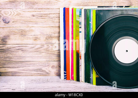 Im Retrostil Bild einer Sammlung von alten Schallplatte Lp's mit Ärmeln auf einer hölzernen Hintergrund mit Platz getönten Kopieren. Stockfoto