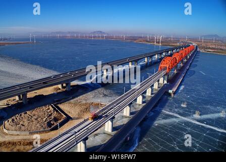 (190701) - Peking, 1. Juli 2019 (Xinhua) - Luftaufnahme auf Jan. 13, 2019 zeigt Arbeiter Tracks für die Beijing-Zhangjiakou Hochgeschwindigkeitsstrecke in Guanting Reservoir Grand Bridge in Nordchina Hebei Provinz übernommen. (Xinhua / Yang Shiyao) Stockfoto