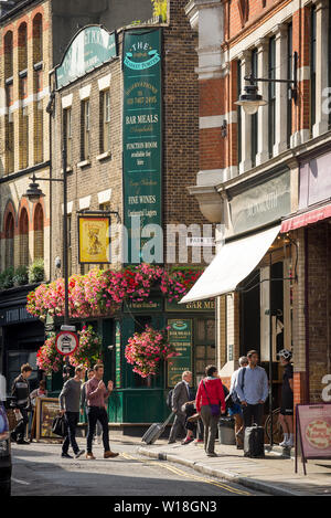 Eine helle und bunte Stoney Street, London in voller Sommerblüte mit dem traditionellen Market Porter Public House Pub und Kuchen- und Kaffeeshops Stockfoto