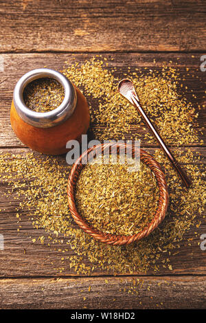 Yerba Mate in Calabash und trockene Kraut in Houten auf Holz- Hintergrund. Ansicht von oben Stockfoto