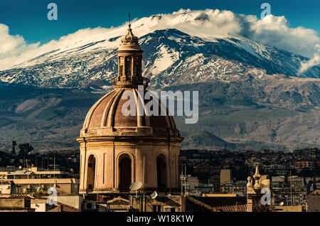 Die Kuppel der Kathedrale in Catania auf dem Hintergrund der Vulkan Ätna im Schnee. Die Ansicht der Stadt Catania mit Blick auf Vulkan Ätna, Sizilien Stockfoto