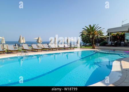 Kreta, Griechenland. Juni 2019. Sonnenliegen am Pool mit Blick auf den Pool auf die Bucht von Chania Norden von Kreta. Stockfoto