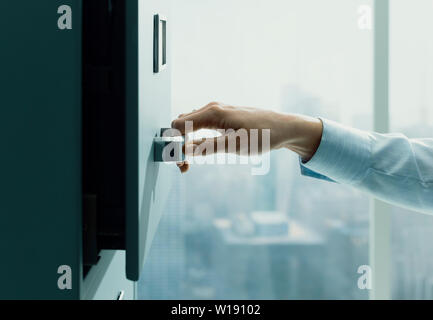 Professionelle Sekretärin arbeiten und Suchen von Dateien im Archiv, sie ist das Öffnen der Schublade ein Aktenschrank Stockfoto