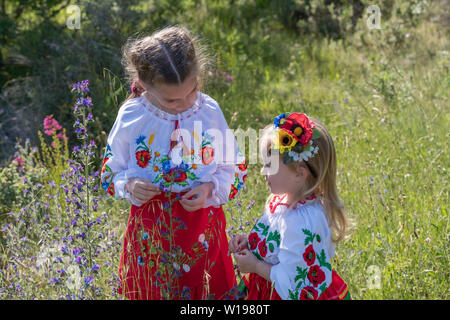 Schwestern in traditionellen ukrainischen Kostüme spielen im Frühjahr auf dem Land Stockfoto