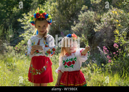 Schwestern in traditionellen ukrainischen Kostüme spielen im Frühjahr auf dem Land Stockfoto