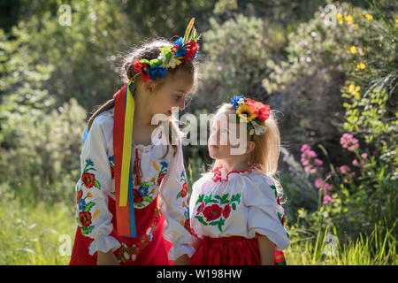 Schwestern in traditionellen ukrainischen Kostüme spielen im Frühjahr auf dem Land Stockfoto