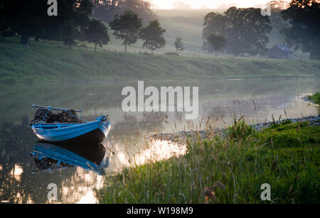 Traditionelle Lachs angeln Boot an der jetzt geschlossenen Fischerei, Canny an norham Bootshaus auf dem Fluss Tweed. Stockfoto