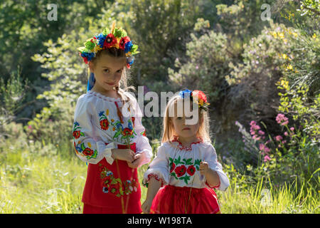 Schwestern in traditionellen ukrainischen Kostüme spielen im Frühjahr auf dem Land Stockfoto