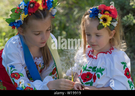 Schwestern in traditionellen ukrainischen Kostüme spielen im Frühjahr auf dem Land Stockfoto