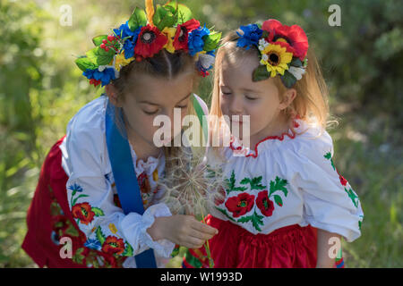 Schwestern in traditionellen ukrainischen Kostüme spielen im Frühjahr auf dem Land Stockfoto