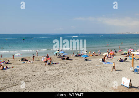 Torrevieja, Spanien - 25. Juni 2019: Urlauber genießen Sie den Sommer Urlaub Strand Ferien am Meer in der Nähe von Mittelmeer von Cabo Roig sandige Küste, sunb Stockfoto