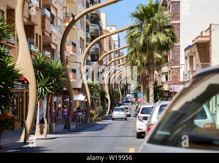 Torrevieja, Spanien - 10. Juni 2019: Besetzt Caballero de Rodas Straße Torrevieja Resort Stadt ungewöhnlich gebogen Straßenbeleuchtung entlang der städtischen Straße Stockfoto