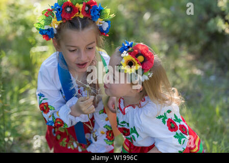 Schwestern in traditionellen ukrainischen Kostüme spielen im Frühjahr auf dem Land Stockfoto