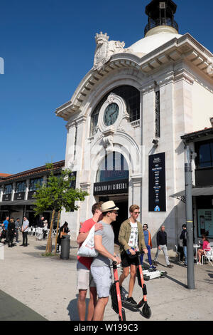 Junge Männer auf Elektroroller in der Straße vor dem Time Out Food Market in Lissabon Portugal Europa EU-KATHY DEWITT Stockfoto