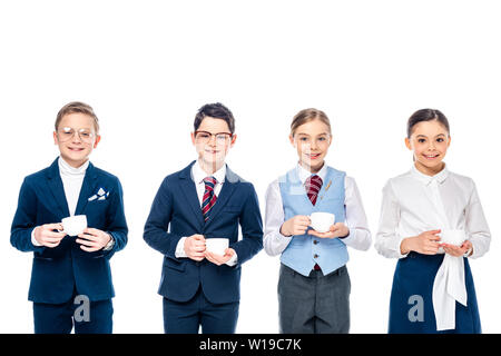 Lächelnd Schulkinder vorgibt, Geschäftsleute halten Kaffeetassen zu sein und die Kamera isoliert auf weißem Stockfoto