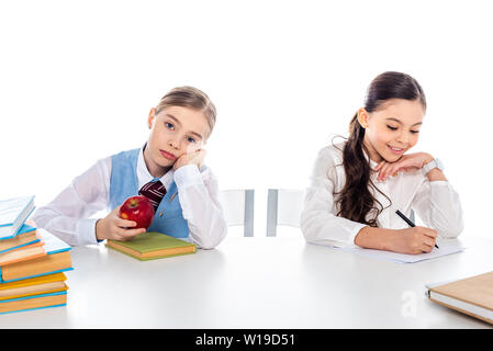 Schülerinnen der gesellschaftsmode Sitzen am Schreibtisch mit Büchern und Schrift auf weißen Isoliert Stockfoto