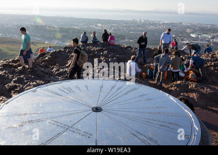 Wanderer geniessen Sie den Sommer Abend Sonnenschein auf dem Gipfel des Arthur's Seat in Holyrood Park, mit Blick auf die Stadt Edinburgh, am 26. Juni 2019 in Edinburgh, Schottland. Arthur's Seat ist ein erloschener Vulkan, der Hauptgipfel der Gruppe von Hügeln in Edinburgh, Schottland, welche Form die meisten Holyrood Park, von Robert Louis Stevenson als "ein Hügel für Größe beschrieben, ein Berg im Rahmen ihrer bold Design" betrachtet wird. Der Hügel erhebt sich über der Stadt auf einer Höhe von 250.5 m (822 ft), einen ausgezeichneten Panoramablick über die Stadt und darüber hinaus. Stockfoto