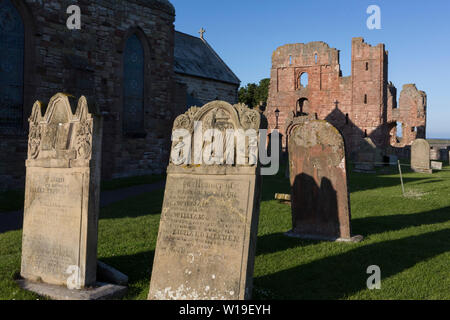 Kirche Grabsteine und die ruinierten Klosters Mauern von Lindisfarne Priory auf der heiligen Insel, am 27. Juni 2019, auf Lindisfarne Insel, Northumberland, England. Das Kloster von Lindisfarne wurde von irischen Mönch St. Aidan gegründet, und das Kloster wurde vor Ende des 634 und Aidan gegründet, es blieb bis zu seinem Tod in 651. Die heilige Insel von Lindisfarne, auch einfach als Holy Island genannt, ist eine Insel vor der Nordostküste Englands. Heilige Insel hat einen aufgezeichneten Geschichte aus dem 6. Jahrhundert AD; es war ein wichtiges Zentrum des Keltischen und Anglo-sächsischen Christentums. Nach der Viking Invasionen und der Keine Stockfoto