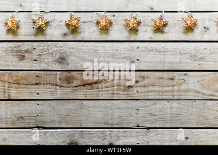 Weihnachtsbeleuchtung, sternförmigen Lichtern auf einen String über Holzbretter mit Kopie Raum Stockfoto