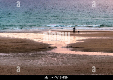 Ein einsamer angler angeln im späten Abendlicht auf Fistral Beach in Newquay in Cornwall. Stockfoto