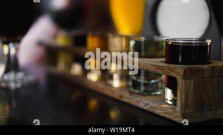 Bunte transparente Cocktails, eine Reihe von Aufnahmen in einer Zeile, sechs Portionen auf einem Stand aus Holz, Substrat. Getränk für das Menü, Restaurant, Bar, Cafe Stockfoto