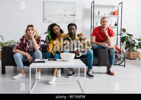 Verärgert multikulturellen friends Meisterschaft im Wohnzimmer Stockfoto