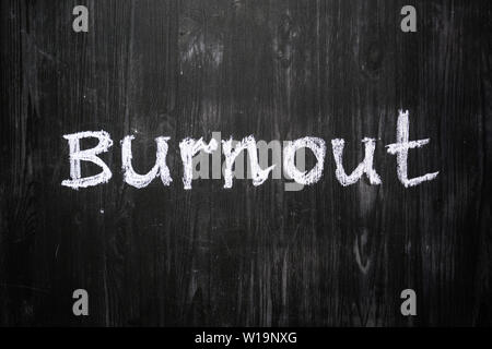 Burnout Wort handschriftlich auf schwarzem Holz Hintergrund. Zeichen, Konzept der psychischen Probleme - das Wort "Burnout" mit Kreide auf Tafel geschrieben Stockfoto