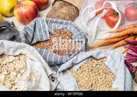 Lebensmittel in wiederverwendbarer Beutel auf natürliche Flachs oder Hanf Hintergrund. Konzept der Null Abfall ethisches Einkaufen: raw vegan Essen wie Obst, Gemüse, Ri Stockfoto