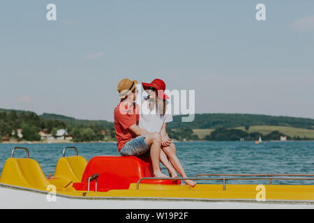 Portrait von lächelnden Paar in Liebe genießen, Tretboot fahren. Freundin und Freund kuscheln sich Tretboot. Stockfoto