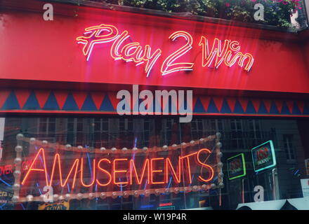 Ein Schaufenster für ein Casino mit rot leuchtendem Neon signs Kunden in London, UK zu gewinnen. Stockfoto