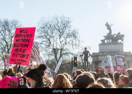 London, UK, 21. Januar 2017. Eine Plakette mit den Laurel Thatcher Ulrich Zitat "Gut erzogene Frauen selten Geschichte machen' ist in der Masse gesehen, wie Menschen auf den Straßen im März der Frauen in London. Der Protest fand am Tag nach der Amtseinführung von Präsident Donald Trump. Bis zu 10.000 nahmen an London als Frauen weltweit den Tag marschieren in einem Akt der internationalen Solidarität gekennzeichnet. Wellington Arch kann im Hintergrund gesehen werden, gekrönt mit der Statue "Frieden absteigend auf dem Wagen des Krieges" Stockfoto