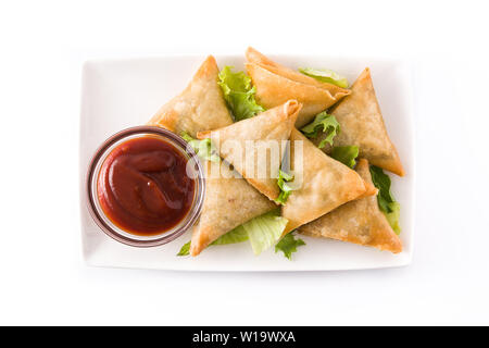 Samsa oder Samosas mit Fleisch und Gemüse auf weißem Hintergrund. Traditionelle indische Küche. Ansicht von oben. Stockfoto