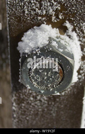 Verwitterte rostige Mutter auf der Schraube mit Schnee im Winter Stockfoto