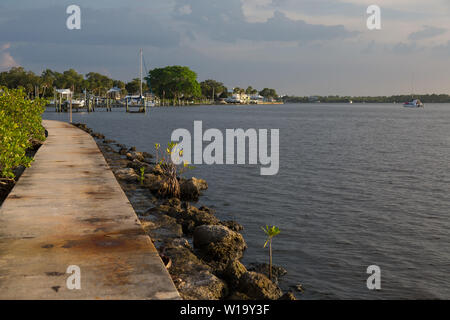 Auf der Suche nach einem rostigen Gehweg entlang der malerischen St. Lucie River in Shepard Park an einem bewölkten Tag in Stuart, Florida, USA. Stockfoto