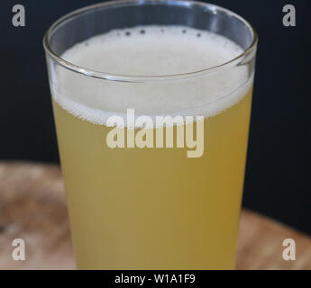 In der Nähe von Glas gefüllt mit Radler, Mischung aus Bier und Sekt Limonade, auf hölzernen Hintergrund Stockfoto
