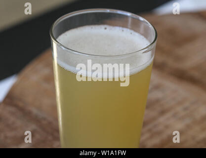 In der Nähe von Glas gefüllt mit Radler, Mischung aus Bier und Sekt Limonade, auf hölzernen Hintergrund Stockfoto