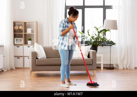 Frau mit Besen fegen Bürstenreinigung Boden Stockfoto