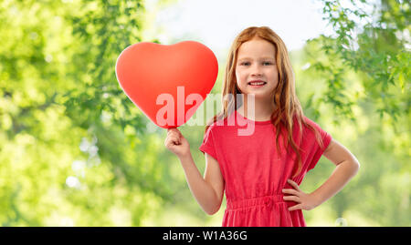 Lächelnd rothaarige Mädchen mit Ballon in Herzform Stockfoto